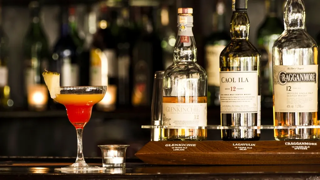 Een cocktail op een bar met flessen op de achtergrond
