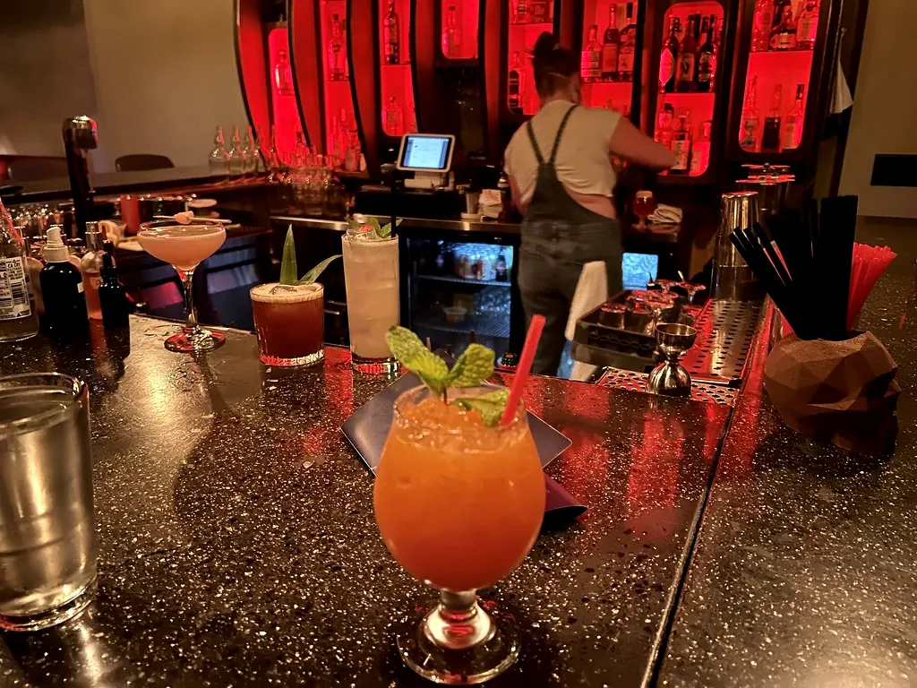 Cocktails op een bar met een bartender op de achtergrond
