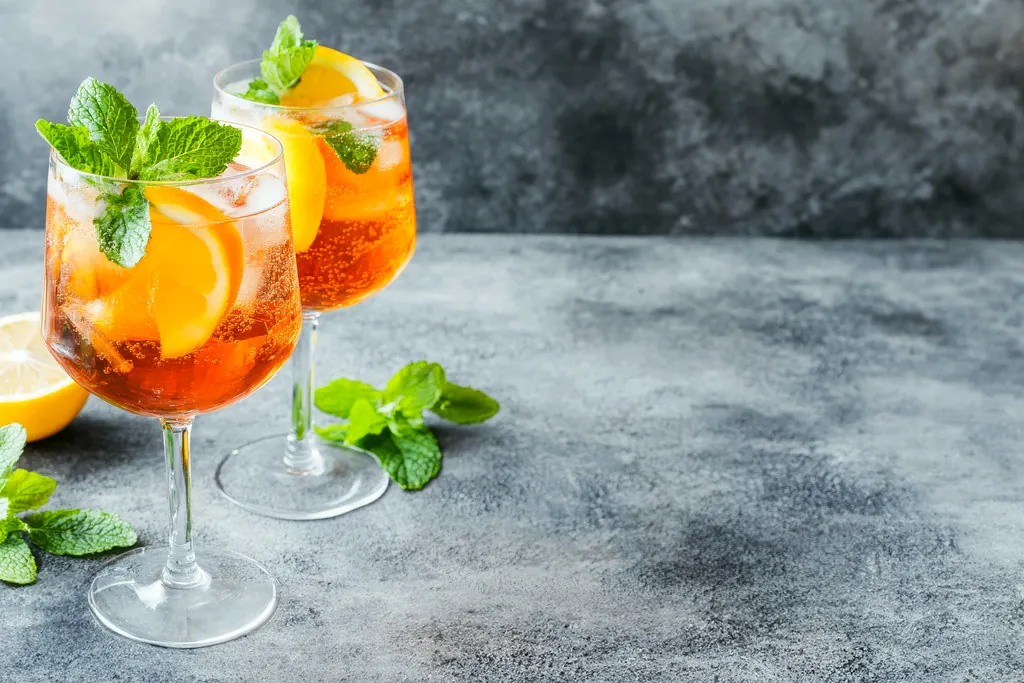 Twee spritz-cocktails met sinaasappel en verse munt